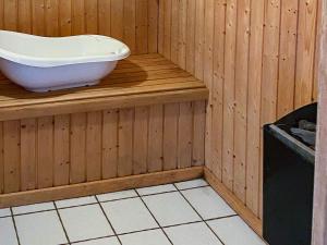 a bathroom with a bath tub on a wooden wall at 4 star holiday home in Nordborg in Nordborg