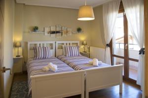 a bedroom with two beds with towels on them at Villa Playa de Barro in Barro de Llanes