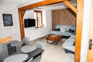 a living room with a couch and a table at Charmant Gîte avec sauna au cœur des Hautes Vosges in Ban-sur-Meurthe-Clefcy