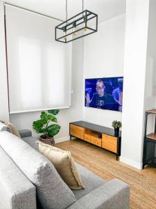 a living room with a couch and a flat screen tv at Suite Ateneo By Silastur in Gijón