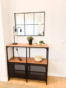 a shelf with a mirror and some plants on it at Suite Ateneo By Silastur in Gijón +43 photos