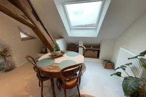 a dining room with a table and a skylight at La Girouette in the heart of a farmhouse in Mittelhausbergen