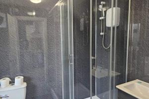 a bathroom with a shower and a toilet and a sink at Studio - Sleeps 2 - Parking - WiFi in Bridgend
