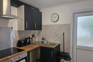 a kitchen with a sink and a clock on the wall at Studio - Sleeps 2 - Parking - WiFi in Bridgend