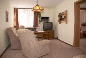 ein Wohnzimmer mit zwei Stühlen und einem Fernseher in der Unterkunft Ferienwohnungen im Harz in Stolberg i. Harz