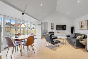 a living room with a couch and a table and chairs at Den Skæve Linje 4C in Løkken