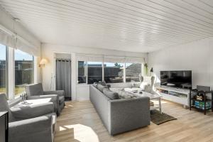 a living room with two couches and a tv at Rent A Cozy Holiday Home At Pirupshvarrevej 5A! in Blokhus