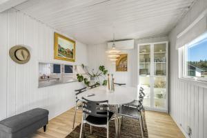 a kitchen with a table and chairs in a room at Rent A Cozy Holiday Home At Pirupshvarrevej 5A! in Blokhus