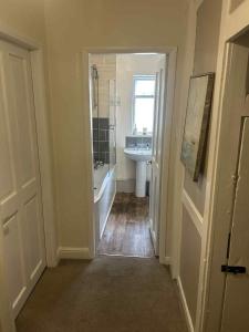 a bathroom with a tub and a sink and a bath tub at Dune Cottage in Whitby