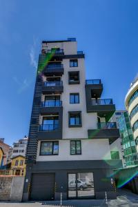 a tall white building with black balconies at La Shara Building in Sofia