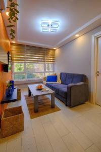 a living room with a blue couch and a table at Big Cozy Apt Close to Kaleici Old Town Sea Shops in Antalya