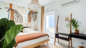 a bedroom with a bed and a desk and a window at Selina Boavista Ericeira in Ericeira