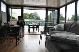 una sala de estar con un sofá y una mesa en Führerscheinfreies mobiles Hausboot, en Rechlin 21 fotos más