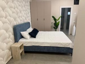 a bedroom with a bed and a blue chair at Sailors Hotel in Ashdod