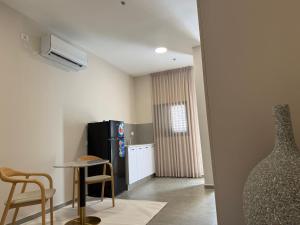 a kitchen with a refrigerator and a table and chairs at Sailors Hotel in Ashdod