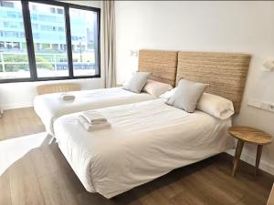 a bedroom with two beds and a large window at Playa Sardinero Little Homes 4 in Santander