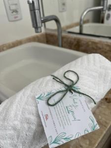 a sign sitting on top of a sink at Pousada Bela By Bia - Comfort in Penha