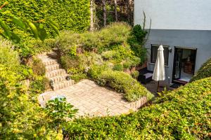 a garden with a stone path and an umbrella at Studio mit Terrasse bei Frankfurt in Bad Vilbel