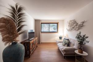 ein Wohnzimmer mit einer Couch und einer großen Vase in der Unterkunft Estrelas do Douro in Gondomar