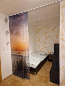 ゲスヴァインシュタインにあるFerienwohnung Kraxnerの壁に絵画が描かれたベッド付きの部屋