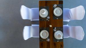 a wooden table with white plates on it at Wayma Paradise Resort in Jambiani