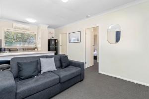 a living room with a couch and a kitchen at Wagga CBD Apartments in Wagga Wagga