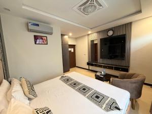 イスラマバードにあるTRH-The Rest Houseのベッド、テレビ、ソファのある寝室 +40枚の写真