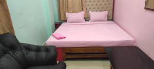 a small bed with a pink mattress and a chair at Gunjan guest house near sskm hospital in Kolkata +3 photos