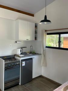 a kitchen with a stove and a sink and a window at Tiny Moor Laguna Garzón in José Ignacio +21 photos