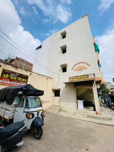 un scooter automobile garé devant un bâtiment dans l'établissement HOTEL SHREE RAM VIJAY Ujjain, à Ujjain