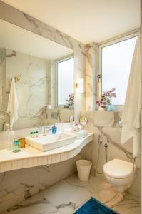 a bathroom with a sink and a toilet and a mirror at El Arbol by The Blue Kite with Rooftop Pool, Kitchen, Wifi, Security,10 Mins to Candolim Beach & 5 mins to Casino in Panaji