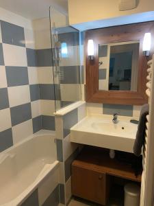 a bathroom with a sink and a tub and a mirror at Argousiers 14, Appartement à Belle Dune in Fort-Mahon-Plage