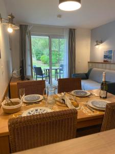 a dining room table with chairs and a living room at Argousiers 14, Appartement à Belle Dune in Fort-Mahon-Plage
