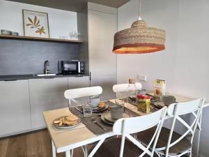 a kitchen with a table with white chairs and a dining room at Playa Sardinero Little Homes 6 in Santander +14 photos