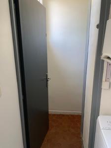 勒卡特港Appartement F2 agréable avec terrasse的浴室设有黑色门和卫生间。