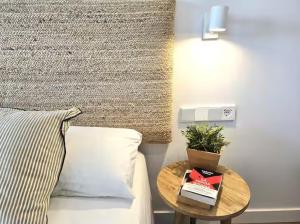 a bedroom with a bed with a table next to it at Playa Sardinero Little Homes 6 in Santander