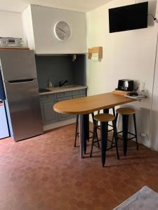 勒卡特港Appartement F2 agréable avec terrasse的配有木桌和冰箱的厨房