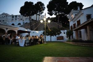 un gruppo di persone seduti ai tavoli in un cortile di Villa El Torreón a Casarabonela Altre 80 foto