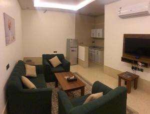 a living room with two couches and a table and a television at اضواء السلام للشقق المخدومة in Medina +29 photos