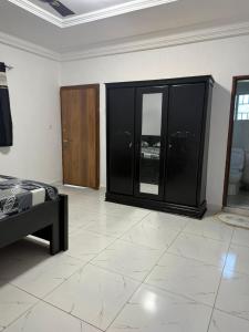 ein Schlafzimmer mit schwarzen Möbeln und weißem Fliesenboden in der Unterkunft Gayern Apartments  + 10 Fotos