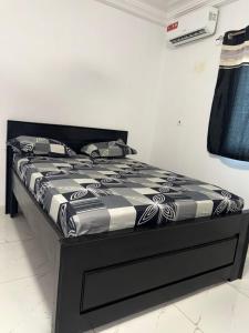 ein Bett mit einer schwarzen und weißen Bettdecke in einem Zimmer in der Unterkunft Gayern Apartments 