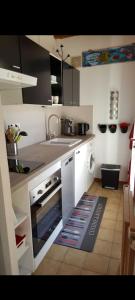 a kitchen with a sink and a stove top oven at Maison mitoyenne 700m de la plage parking privé in Saint-Georges-de-Didonne