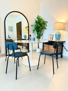 a dining room with a table and chairs and a mirror at By The Beach - Prime location in Sarūq +23 photos
