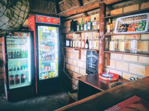 a bar with a refrigerator and a table in front of it at Silver Fish Resort in Maxixe +15 photos