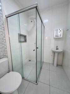 a bathroom with a shower and a toilet and a sink at Casa em Balneário Picarras in Piçarras