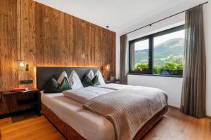 sypialnia z dużym łóżkiem i dużym oknem w obiekcie Chalet L Piz Dolomites w mieście Selva di Val Gardena +26 zdjęć