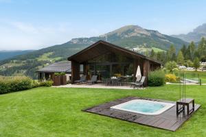 dom z basenem w trawie w obiekcie Chalet L Piz Dolomites w mieście Selva di Val Gardena