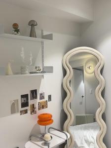 a bedroom with a large circular mirror and a stool at Busan manoah stay hotel in Pusan