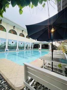 un ombrellone seduto su un tavolo accanto alla piscina di Newcastle Iloilo Hotel a Città di Iloilo