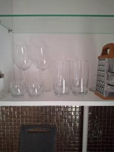 a row of wine glasses sitting on a shelf at Уютная 2-х комнатная квартира in Rudny